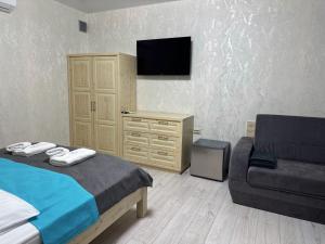 a bedroom with a bed and a chair and a television at IVORY resort and spa in Vynohradiv +68 photos