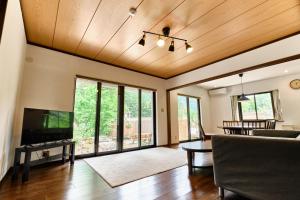 a living room with a television and a couch at BROOK COTTAGE MINAKAMI in Minakami