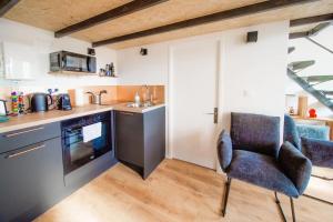 a kitchen with a chair in the middle of a room at The Little Dumont - 2-person Apartment - Croix-Rousse in Lyon