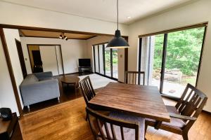 a dining room and living room with a table and chairs at BROOK COTTAGE MINAKAMI in Minakami