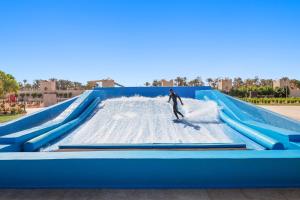 un hombre montando un tobogán acuático en un parque acuático en Pickalbatros Aqua Park Sharm El Sheikh, en Sharm El Sheikh