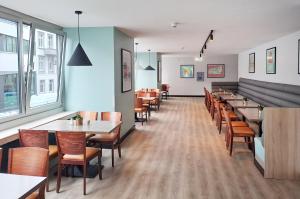 a row of tables and chairs in a restaurant at Garner Hotel Hamburg - Graf Moltke by IHG in Hamburg