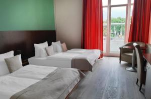 a hotel room with two beds and a window at Garner Hotel Hamburg - Graf Moltke by IHG in Hamburg
