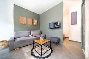 a living room with a couch and a table at Les Amandiers 4 pers- Oullins centre-Lyon in Oullins