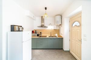 a kitchen with green cabinets and a white refrigerator at Les Amandiers 4 pers- Oullins centre-Lyon in Oullins +23 photos