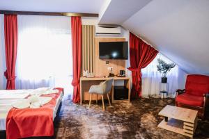 a hotel room with a bed and a desk and a tv at Hotel Relax & Resort Sovata in Sovata