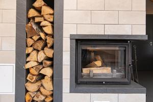 a pile of fire wood next to a fireplace at Anupro Villa in Trakai