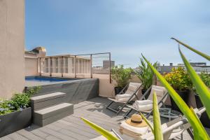 a balcony with chairs and a swimming pool on a building at Aspasios Poble Nou Apartments in Barcelona