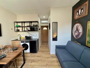 ヴェニシューにあるWild Terrier- Lyon Studioの青いソファとテーブルのあるリビングルーム