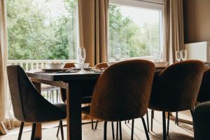 a dining room with a table and chairs and a window at Le Ruisseau - Appartement 8P in Theux