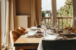 a long table with plates and glasses on a balcony at Le Ruisseau - Appartement 8P in Theux