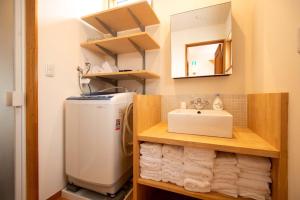 ein kleines Badezimmer mit Waschbecken und Kühlschrank in der Unterkunft Muku House Urayasu in Tokio