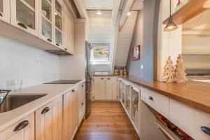 a kitchen with wooden cabinets and a wooden floor at Magnifico duplex en centro Viella in Vielha