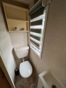 a small bathroom with a toilet and a window at Mobil home 3 chambres 5 personnes Finistère in Clohars-Carnoët +5 photos
