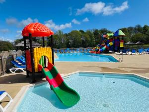a large swimming pool with a playground with a slide at Mobil home 3 chambres 5 personnes Finistère in Clohars-Carnoët