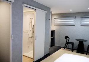 a bathroom with a shower and a table with a stool at Jasmin Jasmin Nishikimachi I - Vacation STAY 11175v in Takamatsu