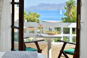 a table and chairs on a balcony with a view of the ocean at Vasilaras Hotel in Skala