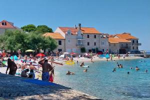 a group of people in the water at a beach at Seaside apartments with a swimming pool Sutivan, Brac - 16846 in Sutivan