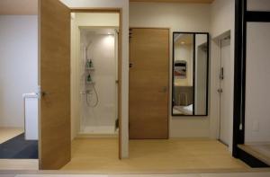 a bathroom with a wooden door and a mirror at Jasmin Nishikimachi 5 - Vacation STAY 13093v in Takamatsu +24 photos
