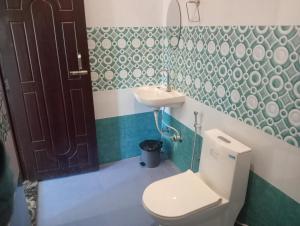 a bathroom with a toilet and a sink at Krishna Hotel & Restaurant in Devaprayāg +32 photos