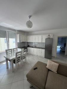 a kitchen and living room with a couch and a table at Holiday Apartmens Neli in Shëngjin