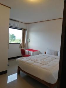 a bedroom with a large bed and a window at ชมวิว บึงโขงหลง in Ban Don Klang