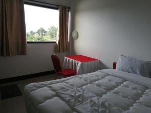 a bedroom with a bed and a table and a window at ชมวิว บึงโขงหลง in Ban Don Klang