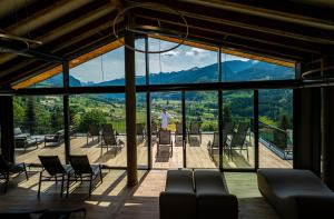 a room with a view of the mountains through glass at La Roccia Wellness Hotel in Cavalese