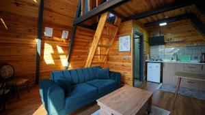 サパンジャにあるHilltop Bungalov Sapanca 3の青いソファとキッチンのあるリビングルーム