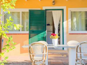 Una mesa y sillas frente a una casa en Appartamento Il Piano - HelloElba, en Rio Marina