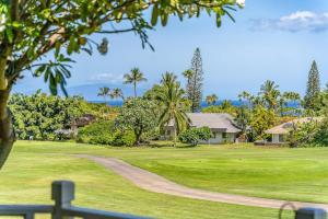 a golf course with palm trees and a house at Grand Champions 163 · GC 163 2BD Wailea Condo w AC Pool Close to in Wailea
