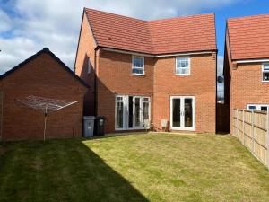 ein Backsteinhaus mit Rasen davor in der Unterkunft Comfortable 5 - Guest Abode - In Quiet Village in Grantham