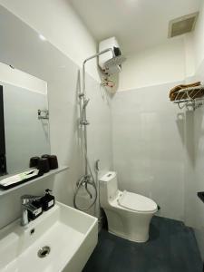 Un baño blanco con inodoro y lavabo. en Homie Ở Đây, en Hue