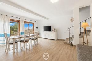 a dining room with a table and chairs and a tv at Garden Delight House in Chia +16 photos