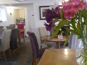 a vase of purple flowers sitting on a table at 3 Millstones Inn in West Bradford