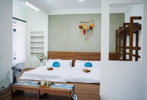 a bedroom with a white bed and a table at Villa Doc Let - Your Home in Doc Let in Nha Trang