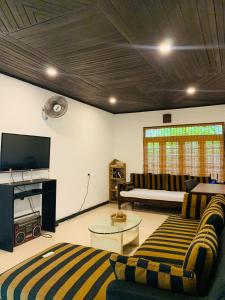 a living room with two couches and a flat screen tv at KAIMANA HOUSE - 3 Min walk to the beaches in Tangalle