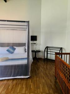 a bedroom with a bed with a canopy and a table at KAIMANA HOUSE - 3 Min walk to the beaches in Tangalle