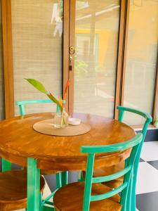 a wooden table with two chairs and a vase on it at KAIMANA HOUSE - 3 Min walk to the beaches in Tangalle +11 photos