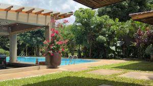 a swimming pool next to a resort with a garden at Tulivu Kilimanjaro Retreat in Msaranga