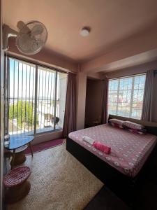 a bedroom with a bed and a large window at GRETZbnb in Shillong