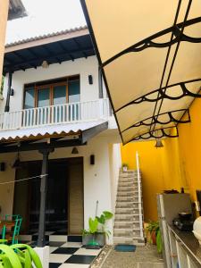 a yellow and white house with a checkered floor at KAIMANA HOUSE - 3 Min walk to the beaches in Tangalle