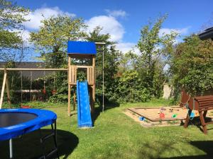 un parque infantil con una torre y un tobogán en Dörpshus im strandnahen Bojendorf, en Fehmarn