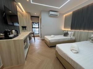 a hotel room with two beds and a kitchen at Bed by Tha-Pra SHA Plus in Bangkok