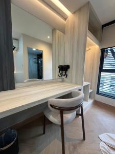 a bathroom with a vanity with a chair and a mirror at Bed by Tha-Pra SHA Plus in Bangkok +39 photos
