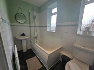 Un baño con bañera, lavabo e inodoro. en Spacious 3bedroom Apartment-Short and Long Stays-Contractors and Families, en Dunston