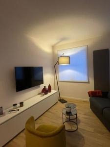 a living room with a tv and a couch at Otto House short stay with style in San Daniele del Friuli