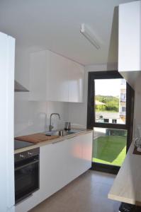 アーレスにあるPrecioso apartamento con garaje en Aresのシンクと窓のある白いキッチン