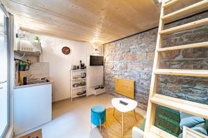 una piccola cucina e soggiorno con un muro in pietra di Le petit Victor Hugo - studio Bellecour a Lione