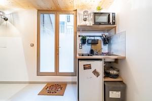 una piccola cucina con frigorifero e forno a microonde di Le petit Victor Hugo - studio Bellecour a Lione